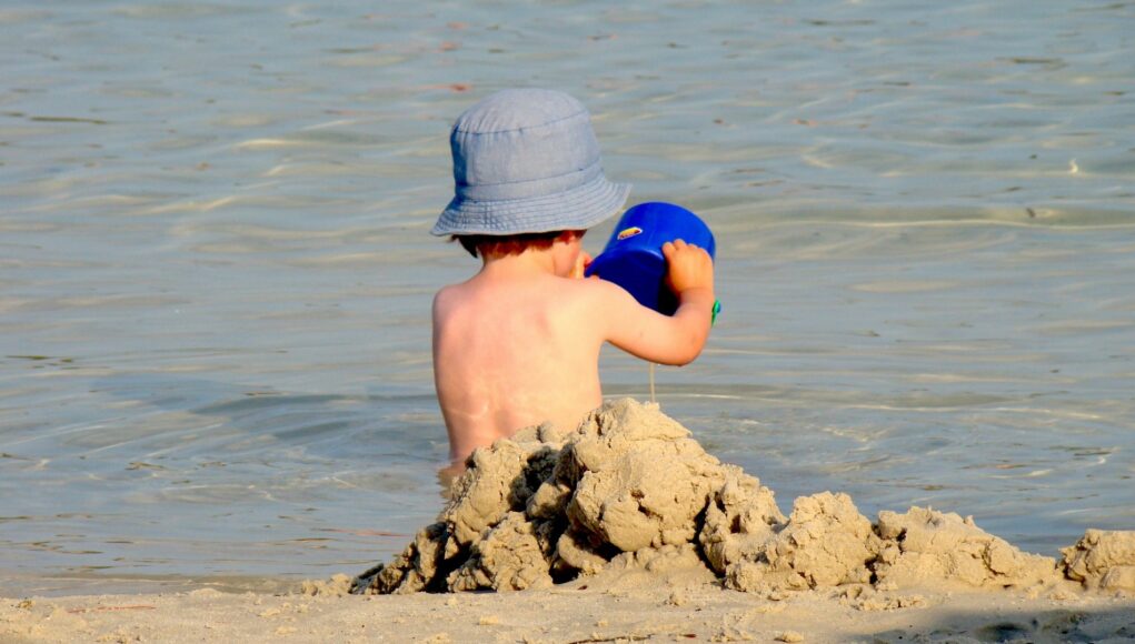 dijete se igra sa pijeskom na plaži